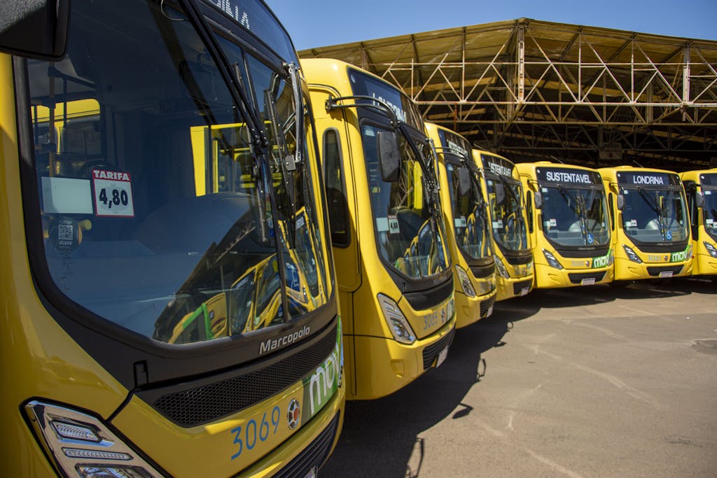 Bright yellow buses lined up at Londrina's public transport station under sunny skies.