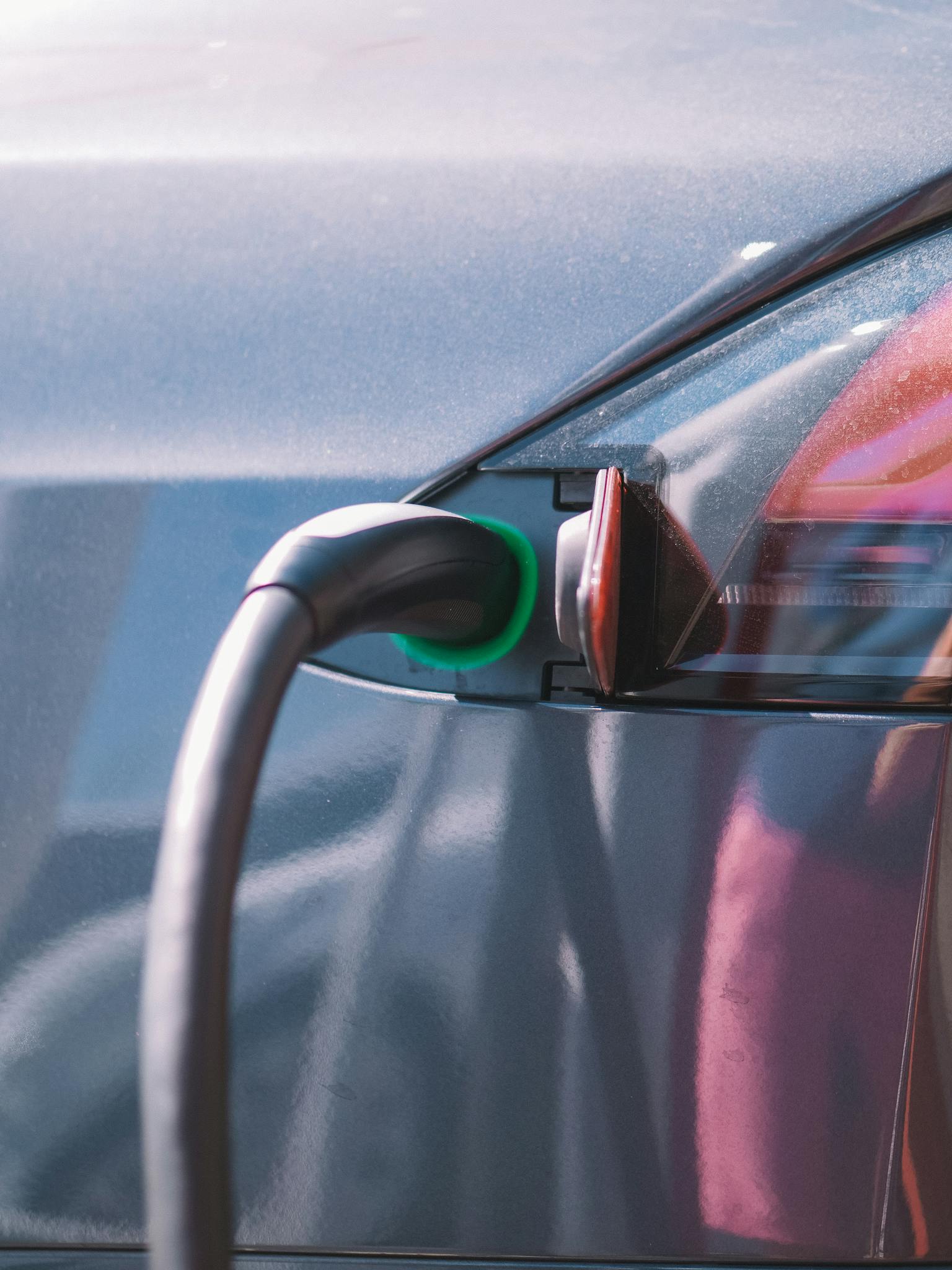 Close-up of an electric car plugged into a charging station, showcasing modern technology.